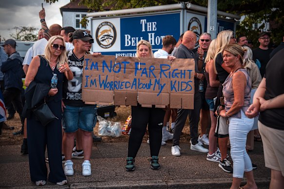 Una mujer sostiene un cartel durante una protesta fuera del Hotel Bell en Epping, Inglaterra. 
