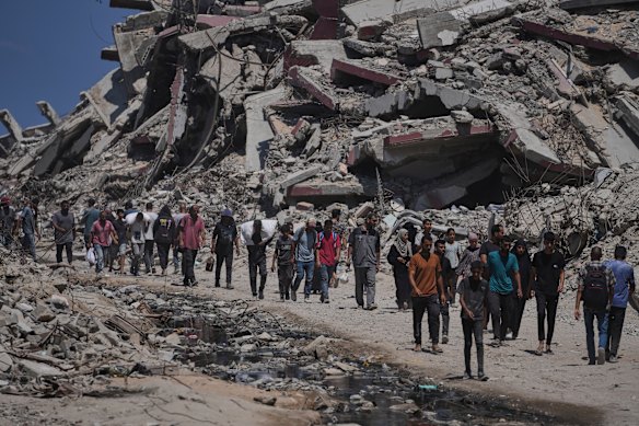 Los palestinos llevan sacos de ayuda descargados de camiones en el norte de Gaza que se habían dirigido a la ciudad de Gaza el domingo.