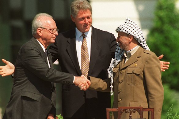 El primer ministro israelí, Yitzhak Rabin (izquierda) y el líder palestino Yasser Arafat se dan la mano de los acuerdos de Oslo en la Casa Blanca en septiembre de 1993, con el presidente de los Estados Unidos, Bill Clinton.