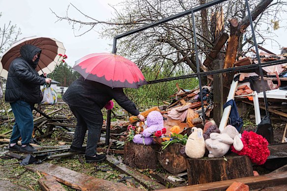 Las mujeres ucranianas pusieron flores por los escombros de una casa destruida donde tres niños fueron asesinados por una huelga rusa en Korostyshiv, región de Zhytomyr, en mayo.