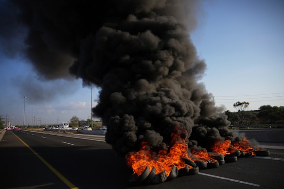 Los neumáticos se incendian para bloquear una carretera durante una protesta cerca de Jerusalén el domingo.