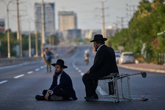 Dos hombres bloquean una carretera para protestar contra el reclutamiento en Bnei Brak el 19 de agosto.