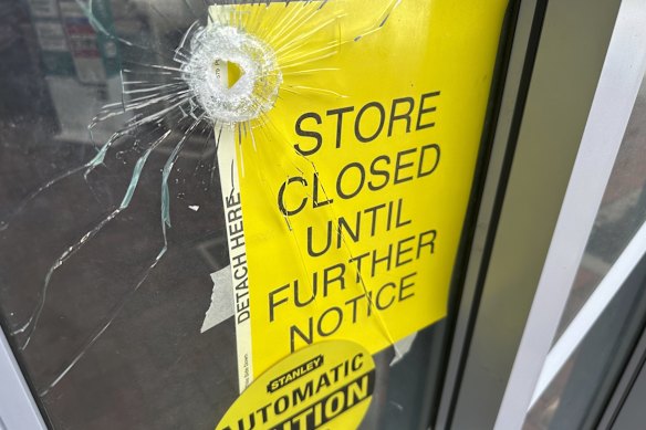 Un agujero de bala en la puerta de una farmacia cerca de donde la policía dice que un hombre estaba disparando en la sede de los Centros para el Control y la Prevención de Enfermedades el 8 de agosto.