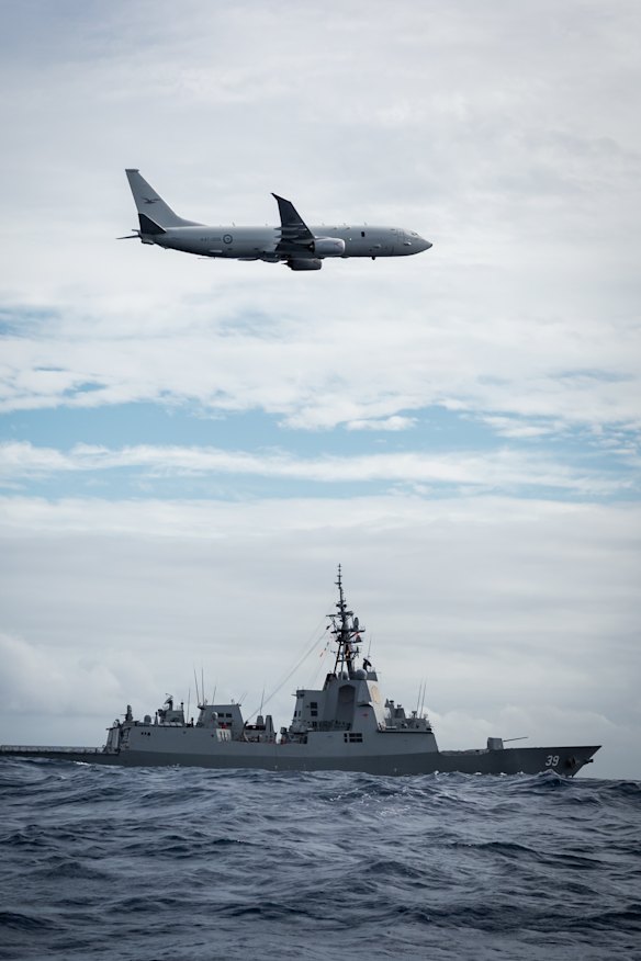 Un avión de cazador submarino Peeidón P-8A australiano vuela sobre HMAS Hobart en 2022.