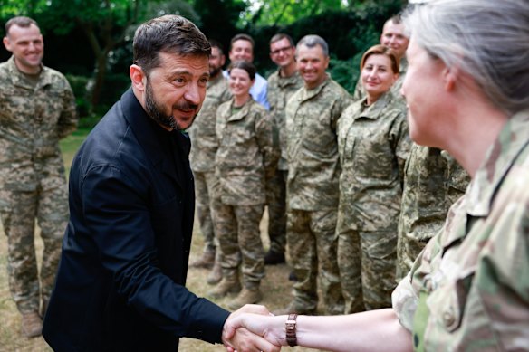El presidente ucraniano, Volodymyr Zelensky, da la mano con un soldado de la Operación Interflex en junio.