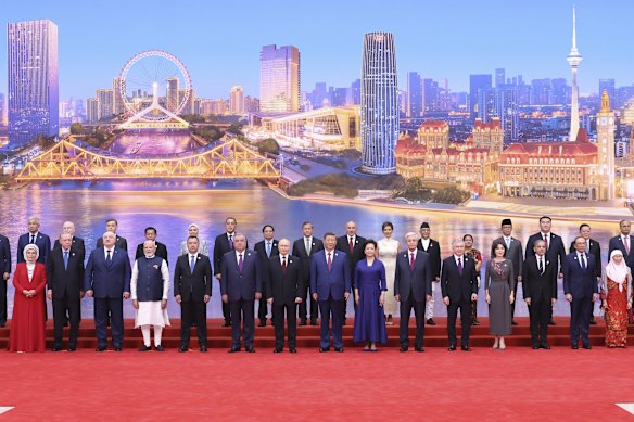 Xi Jinping y su esposa, Peng Liyuan, (Center) posan para una foto grupal con invitados internacionales antes de una cumbre bienvenida al banquete.
