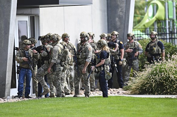 Los agentes de la ley se preparan para barrer un edificio en la universidad.