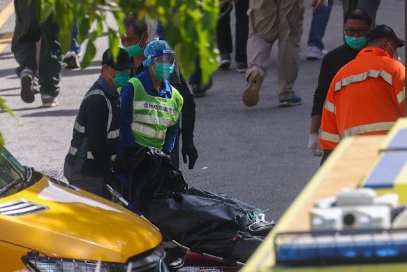 Los trabajadores de búsqueda y rescate trasladan los cuerpos a un camión.