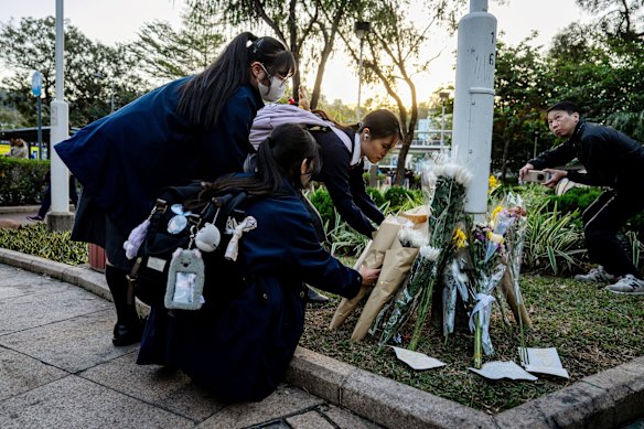 Los estudiantes traen homenajes florales a las víctimas el viernes.