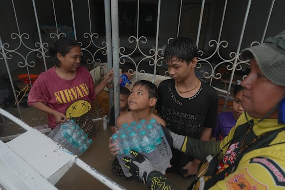 Una familia recibe agua de los trabajadores humanitarios en Hat Yai.